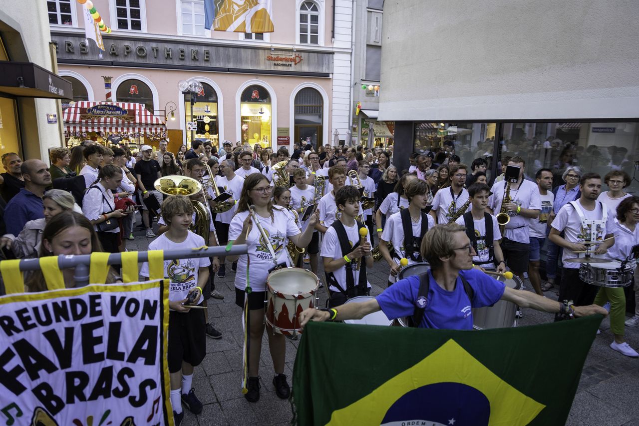 The Freunde von Favela Brass banner and a Brazilian flag carried through the crowd at the Rakoczy Festival, Bad Kissingen, July 2026