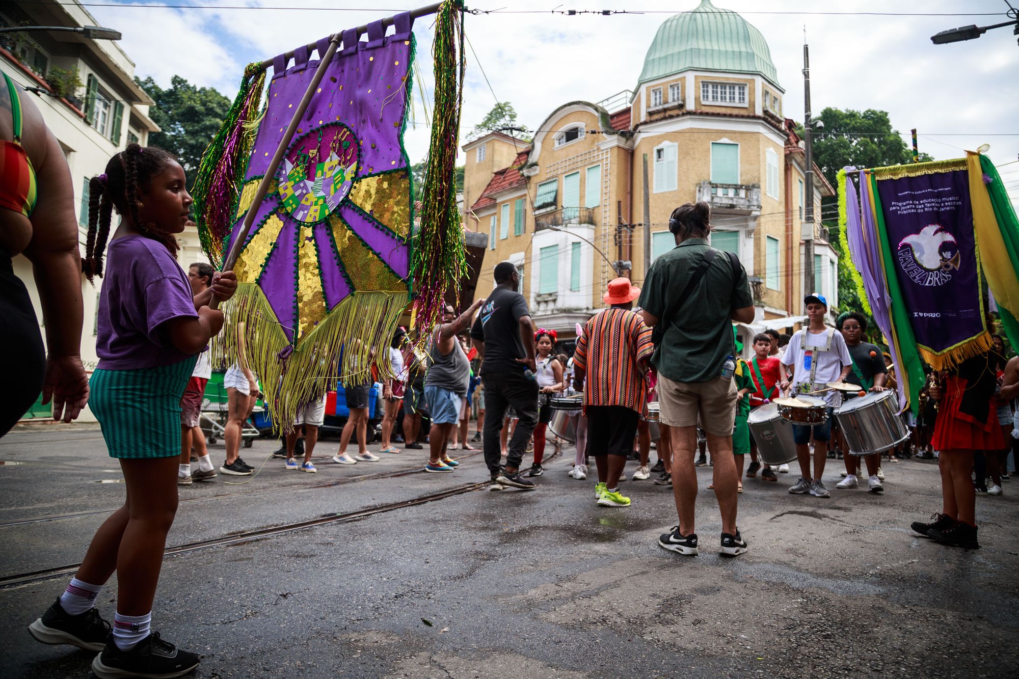 Favela Brass students parading with estandartes in Rio de Janeiro during carnival 2026